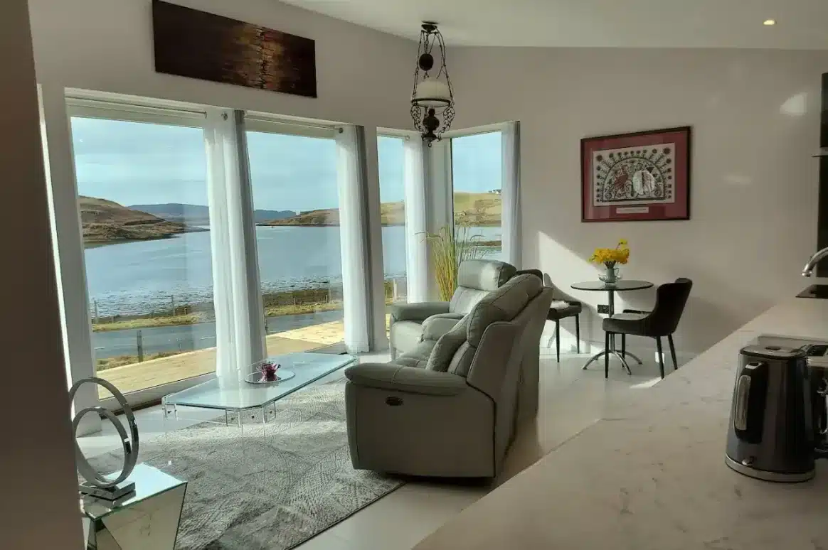 Living room with full panoramic windows and ocean view.